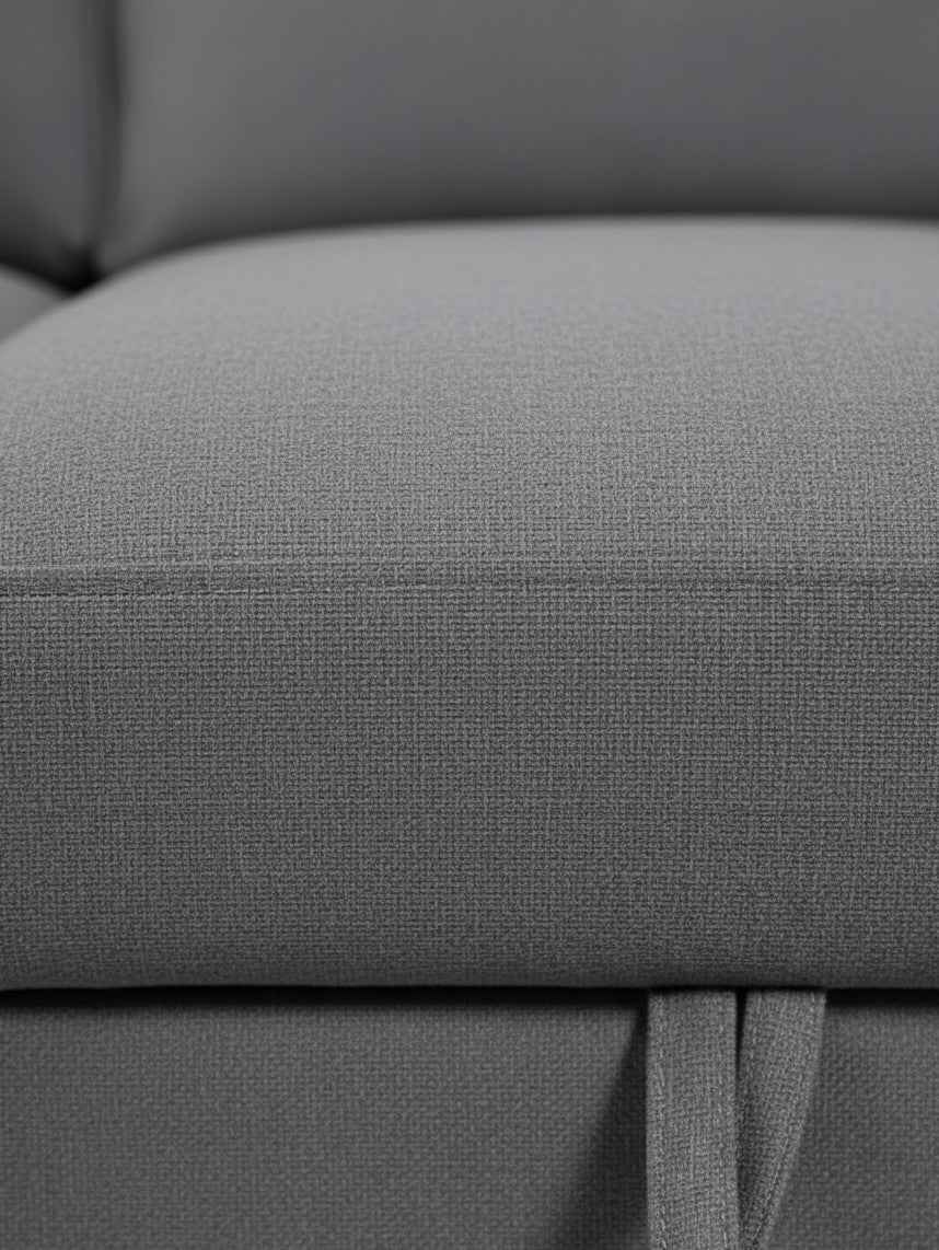 Gros plan sur le tissu gris texturé du sofa-lit sectionnel Olympe de TOCO Meubles avec sangle de tirage visible