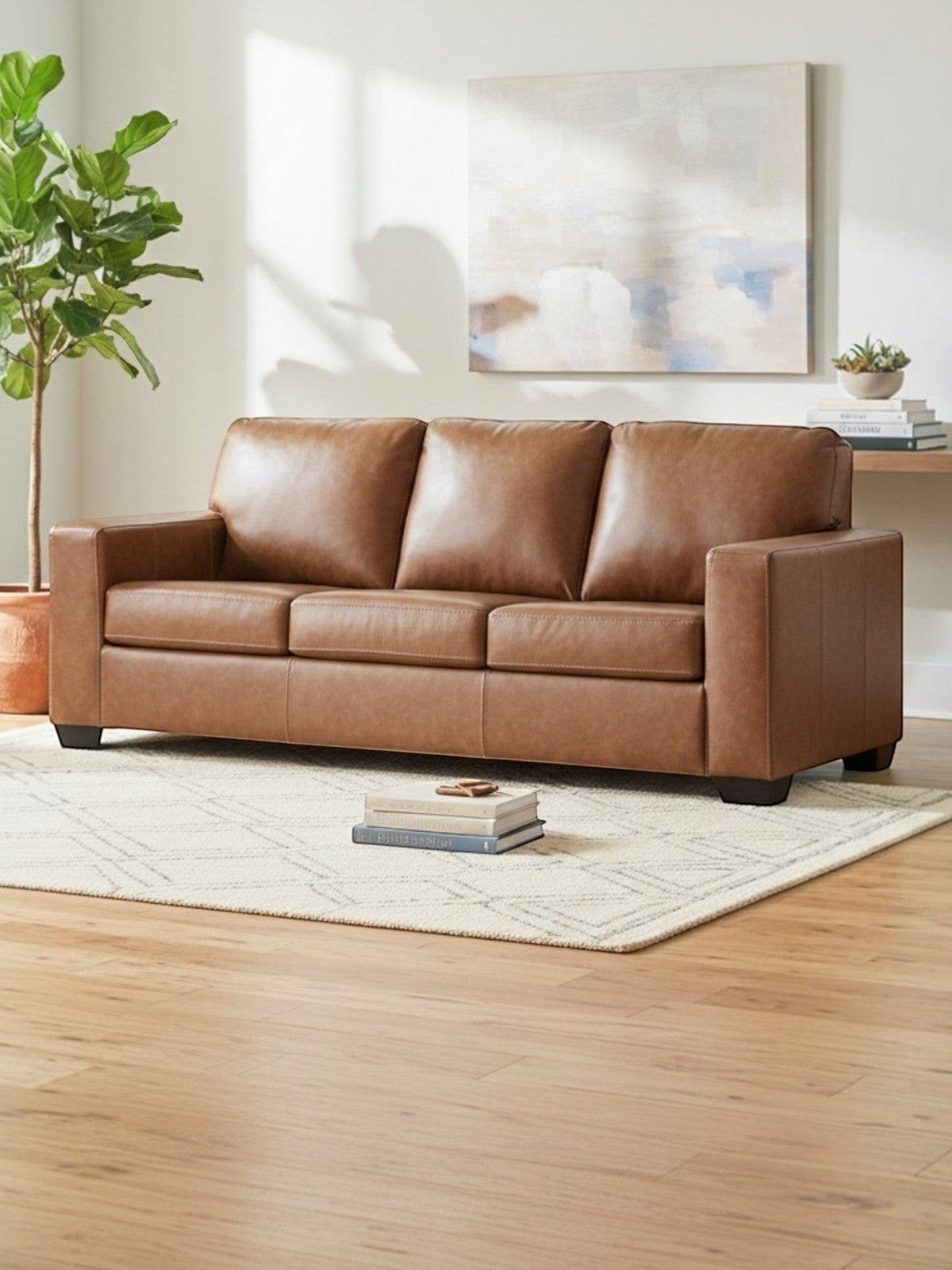 Sofa-lit Jelani de TOCO Meubles en cuir marron, design contemporain confortable dans un salon lumineux.