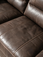 Gros plan sur le revêtement en aspect cuir marron du sofa-lit Kairo de TOCO Meubles avec ses coutures apparentes.