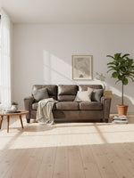 Sofa-lit Kairo de TOCO Meubles en aspect cuir marron avec coussins décoratifs dans un salon lumineux et moderne