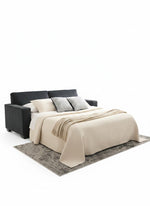 Sofa-lit Marcel de TOCO Meubles en mode lit avec une literie beige sur un tapis gris dans un intérieur moderne