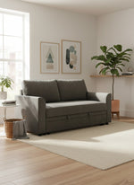 Sofa-lit Nico gris de TOCO Meubles dans un salon moderne et lumineux avec tapis beige et plante verte.