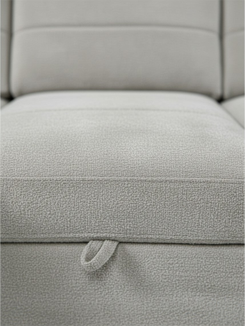Gros plan sur le tissu texturé gris clair du sofa-lit sectionnel Montel de TOCO Meubles avec languette de tirage