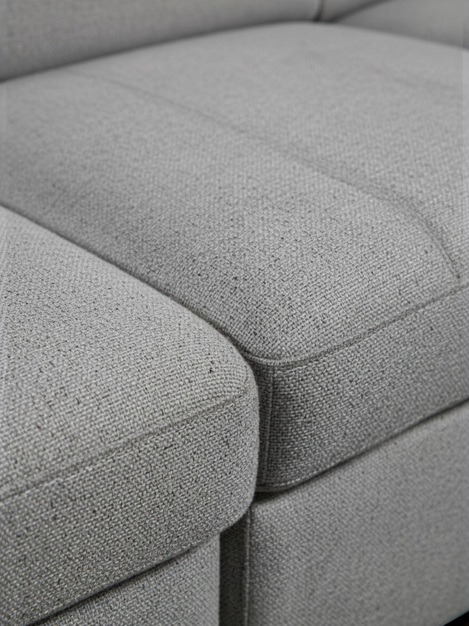 Gros plan sur le revêtement en tissu gris texturé du sofa-lit Pratiquo de TOCO Meubles