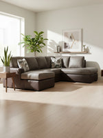 Sofa-lit Zuri de TOCO Meubles en aspect-cuir bicolore gris et brun dans un salon moderne et lumineux.