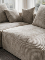 Sofa modulaire Nola de TOCO Meubles en velours côtelé beige avec ottoman et coussins assortis