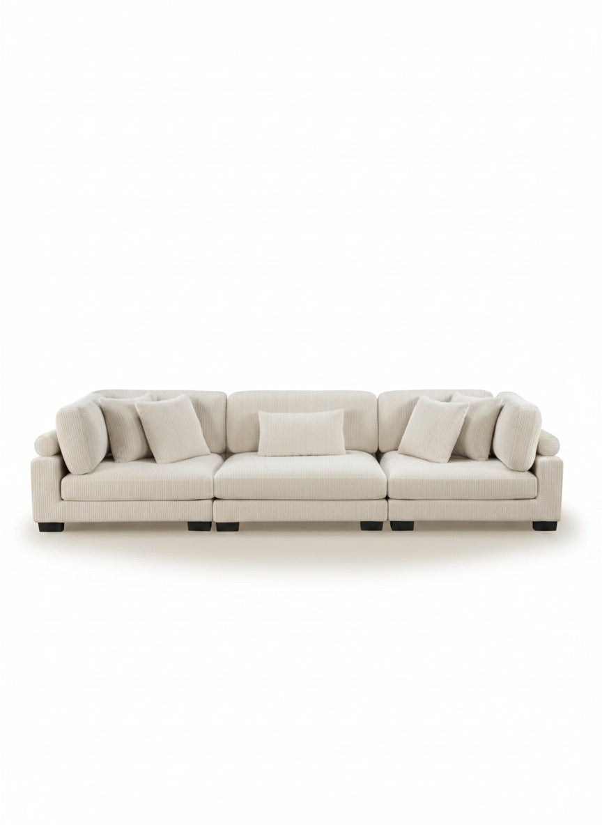 Sofa modulaire TOCO Meubles Traverse en velours côtelé beige avec coussins décoratifs sur fond blanc