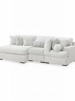 Sofa modulaire Nuage de TOCO Meubles, sectionnel blanc moelleux avec chaise longue et coussins décoratifs texturés.