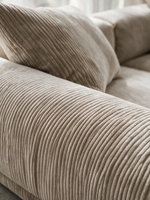 Sofa modulaire Nola beige en velours côtelé avec ottoman, présenté dans un salon lumineux par TOCO Meubles