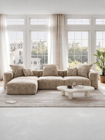 Sofa modulaire Nola de TOCO Meubles en velours côtelé beige avec ottoman dans un salon lumineux et moderne