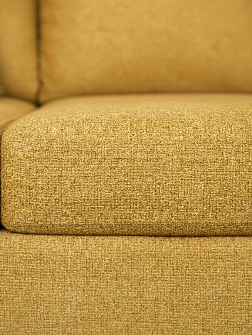 Gros plan sur le tissu texturé jaune tournesol du canapé Owick de TOCO Meubles