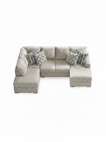 Sofa sectionnel en U beige TOCO Meubles avec coussins décoratifs à motifs géométriques sur fond blanc