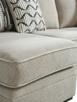 Gros plan sur le tissu texturé beige du sofa sectionnel Kael de TOCO Meubles avec coussins décoratifs à motifs