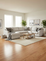 Sofa sectionnel beige TOCO Meubles avec méridienne, coussins décoratifs et table basse en bois dans un salon moderne