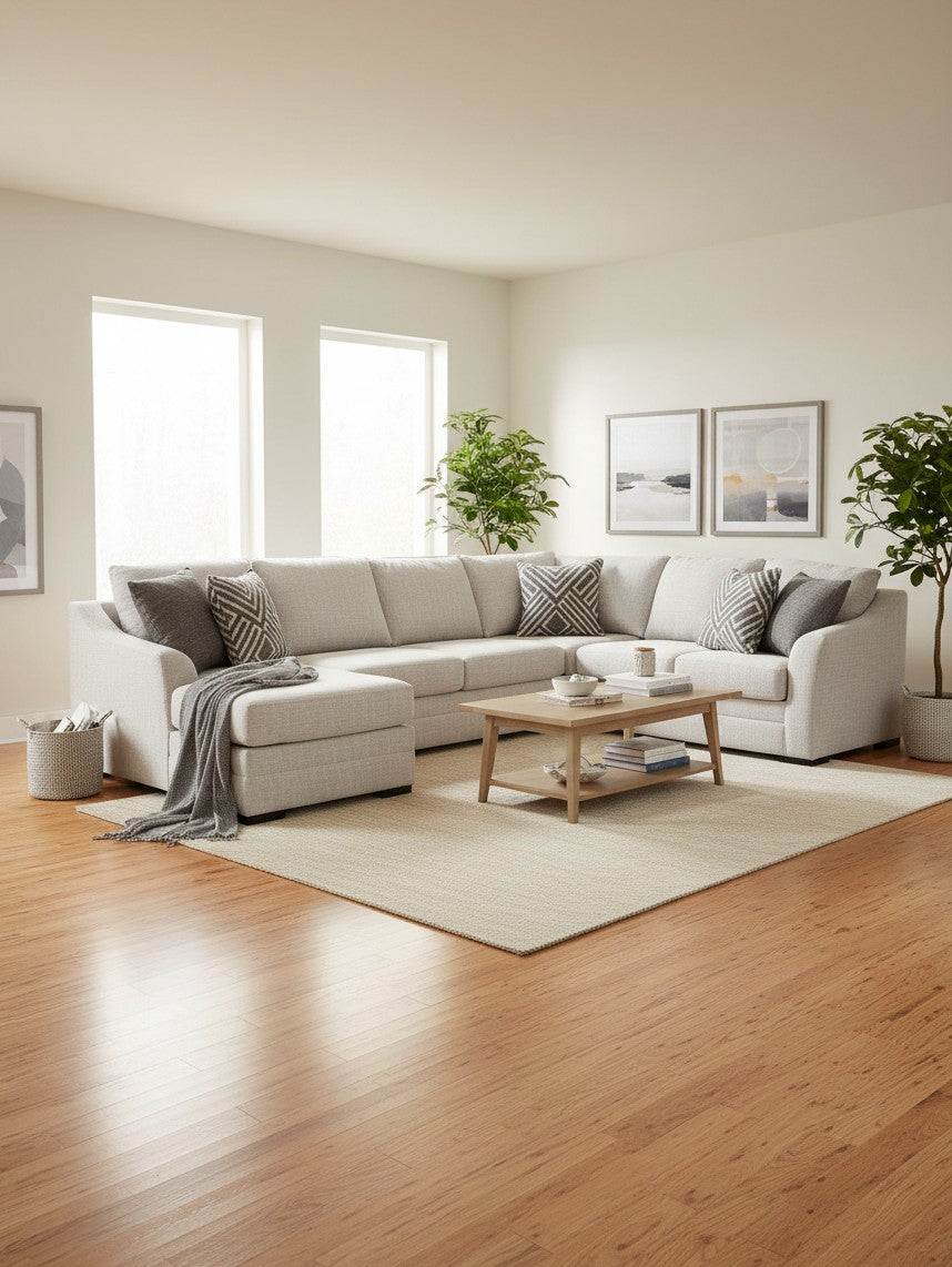 Sofa sectionnel beige TOCO Meubles avec méridienne, coussins décoratifs et table basse en bois dans un salon moderne