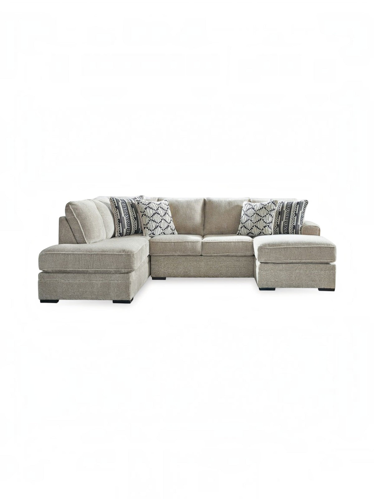 Sofa sectionnel Kael beige de TOCO Meubles avec coussins décoratifs à motifs géométriques sur fond blanc