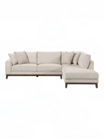 Sofa sectionnel Calvi de TOCO Meubles en tissu chenille beige avec coussins décoratifs et pattes en bois brun foncé.