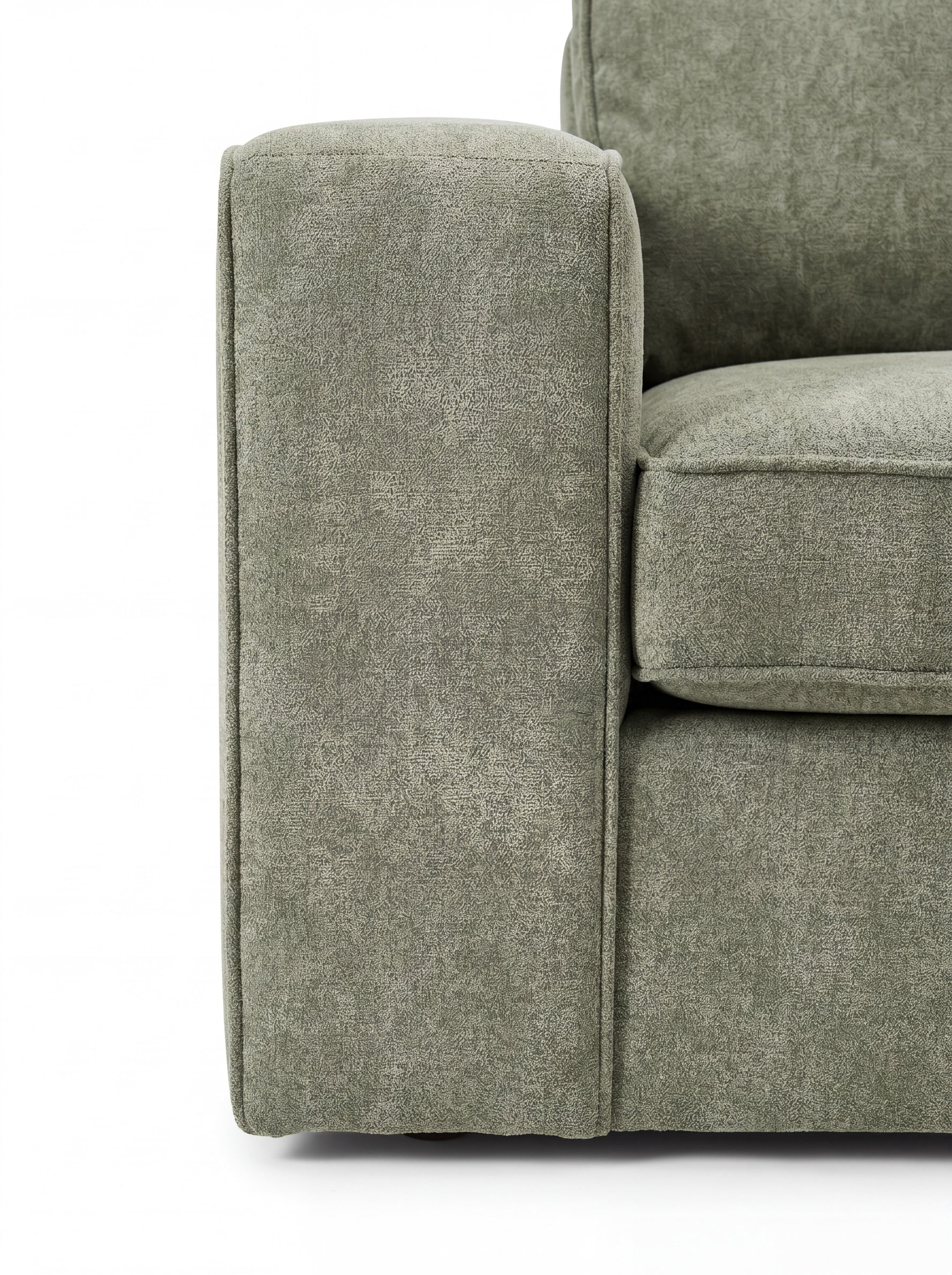 Gros plan sur l'accoudoir et l'assise du sofa sectionnel Forest vert sauge personnalisable chez TOCO Meubles
