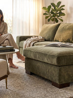Sofa sectionnel Forest TOCO Meubles en velours vert olive avec repose-pieds dans un salon lumineux et moderne