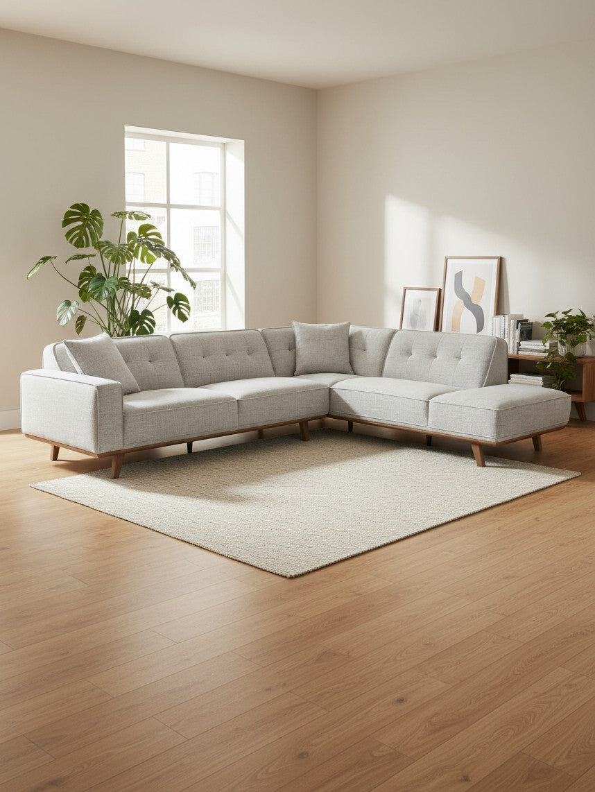 Sofa sectionnel TOCO Meubles Célestin gris clair avec pieds en bois dans un salon moderne et lumineux