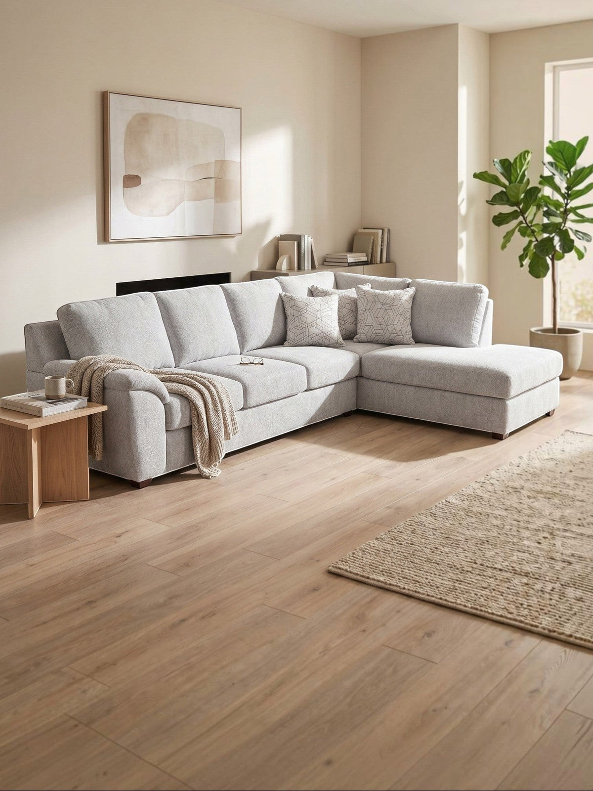 Sofa sectionnel gris clair TOCO Meubles avec méridienne, coussins décoratifs et design moderne dans un salon lumineux.
