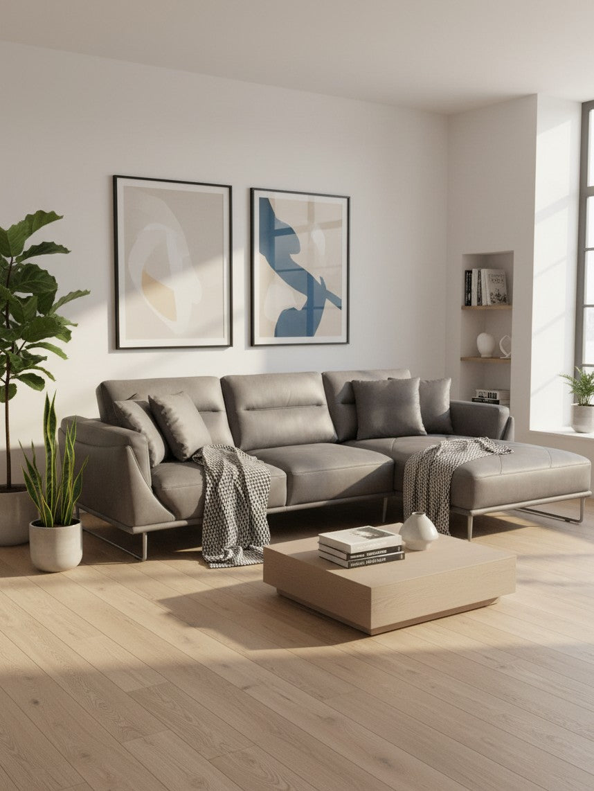 Sofa sectionnel gris TOCO Meubles avec méridienne à droite, quatre coussins et jeté dans un salon moderne lumineux.