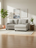 Sofa sectionnel Aldo de TOCO Meubles en tissu texturé gris clair avec méridienne dans un salon lumineux et moderne.