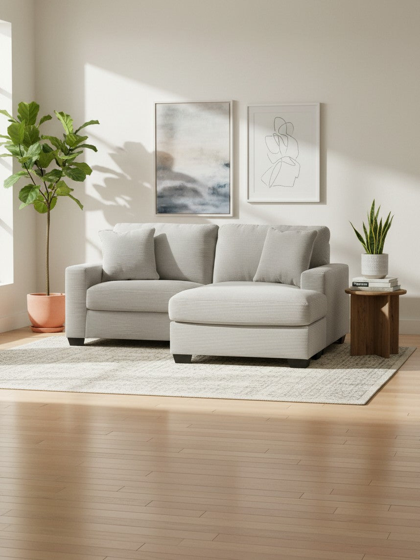 Sofa sectionnel Aldo de TOCO Meubles en tissu texturé gris clair avec méridienne dans un salon lumineux et moderne.