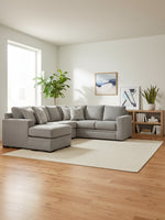 Sofa sectionnel Ugo gris par TOCO Meubles dans un salon lumineux avec tapis beige et plantes vertes