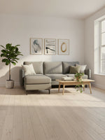 Sofa sectionnel Neo gris de TOCO Meubles dans un salon lumineux avec table basse en bois et plante verte