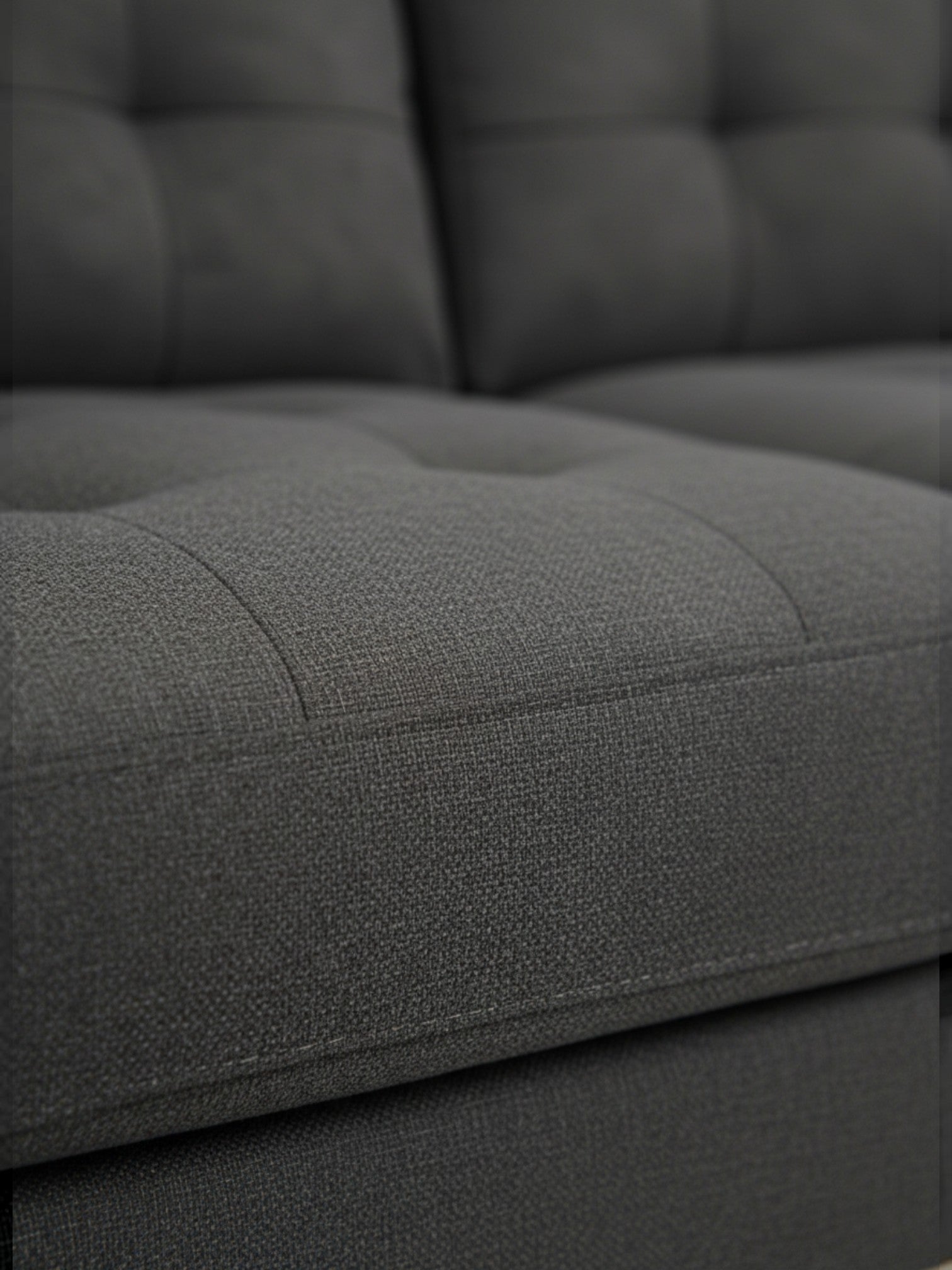 Gros plan sur le tissu gris texturé du sofa sectionnel Khamo de TOCO Meubles avec finition capitonnée