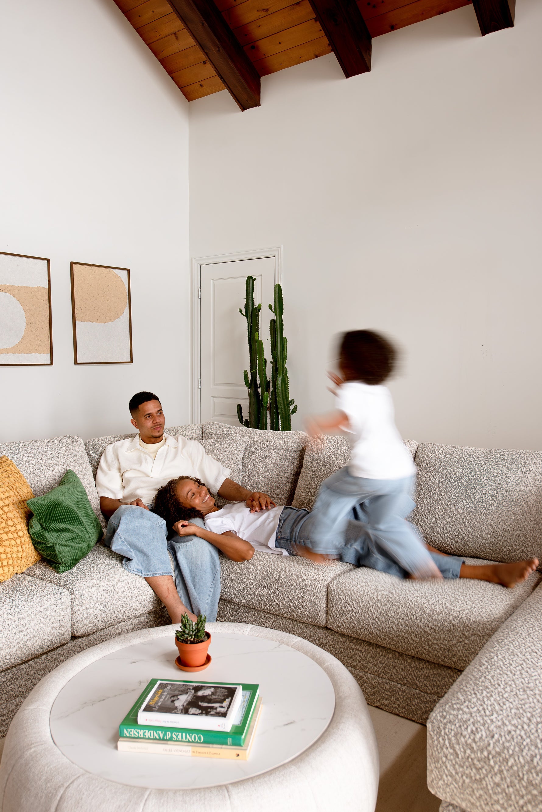 Famille relaxant sur le sofa sectionnel Melissa personnalisable de TOCO Meubles en tissu texturé gris clair.