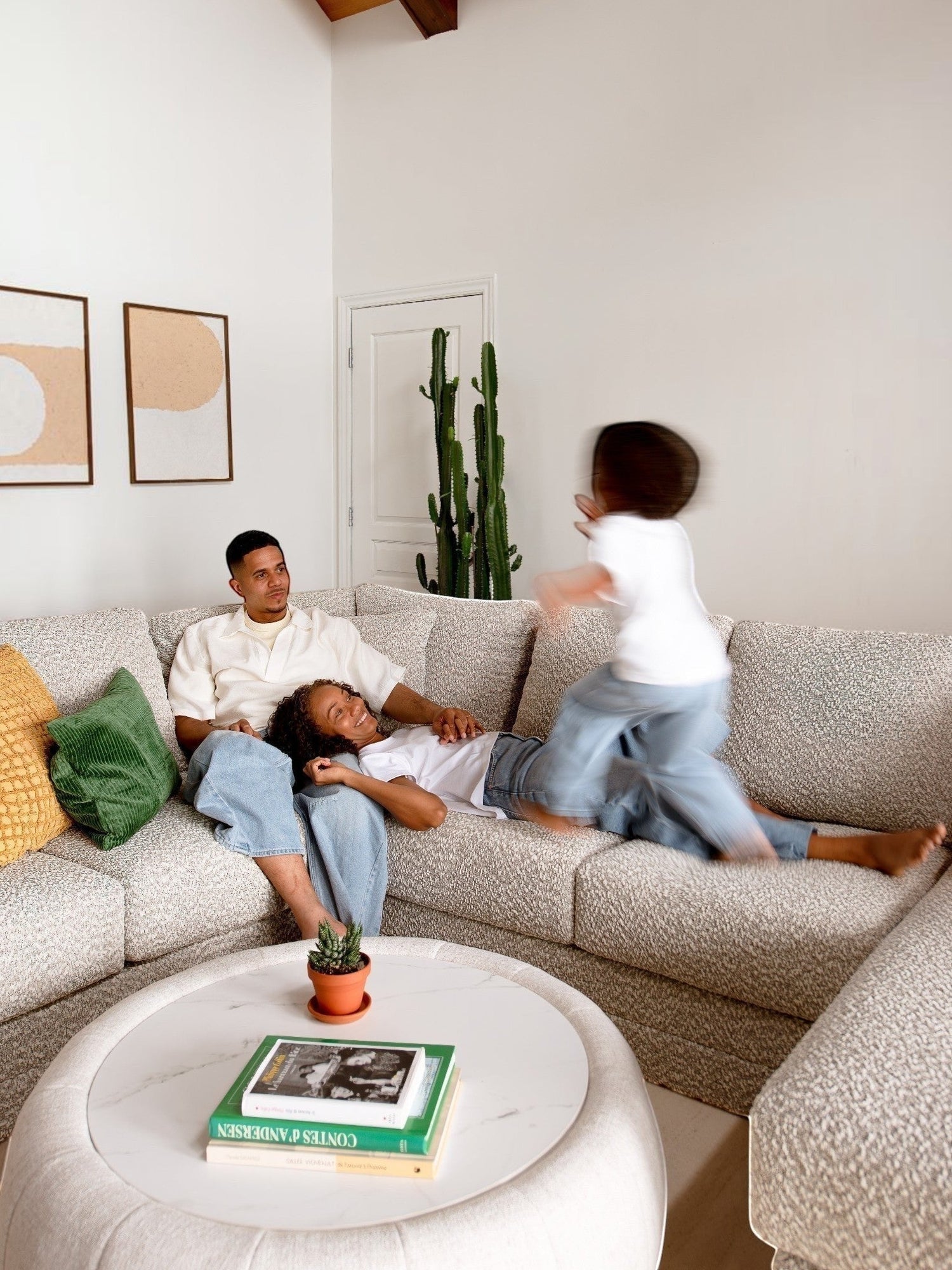 Famille relaxant sur le sofa sectionnel Melissa personnalisable de TOCO Meubles en tissu texturé gris clair.