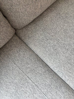 Gros plan sur le revêtement en tissu gris texturé du sofa sectionnel personnalisable Prestige de TOCO Meubles.