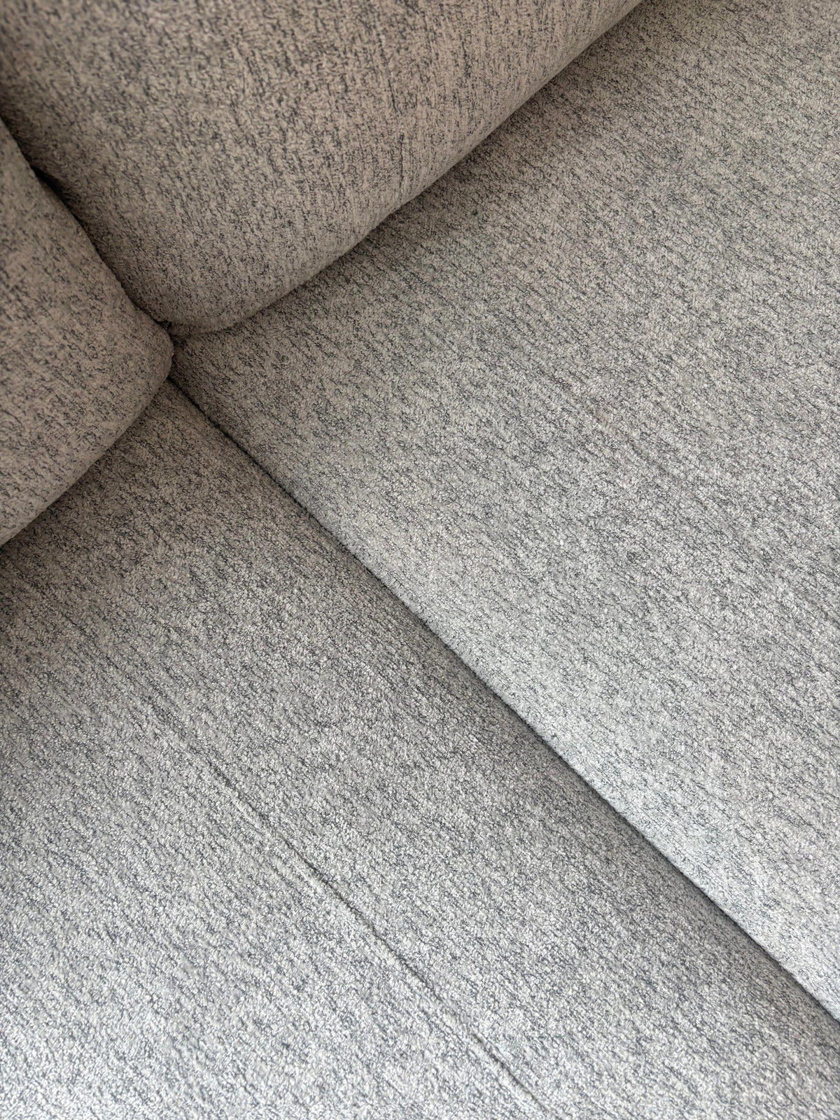 Gros plan sur le revêtement en tissu gris texturé du sofa sectionnel personnalisable Prestige de TOCO Meubles.