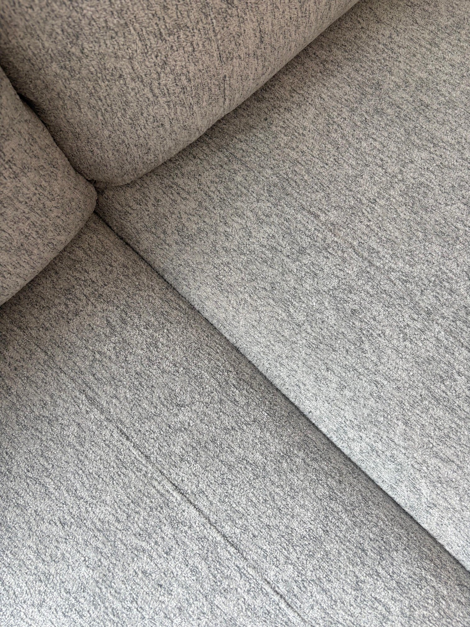 Gros plan sur le revêtement en tissu gris texturé du sofa sectionnel personnalisable Prestige de TOCO Meubles.