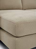 Gros plan sur le revêtement en velours côtelé beige du sofa sectionnel Zahra de TOCO Meubles