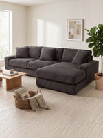 Sofa sectionnel TOCO Meubles Alpaga en velours côtelé gris foncé avec méridienne dans un salon moderne et lumineux