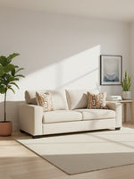 Sofa Toscana beige par TOCO Meubles avec coussins à motifs géométriques dans un salon lumineux et moderne
