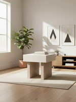 Table d'appoint Ulric par TOCO Meubles avec plateau en pierre beige et pieds en bois clair dans un salon moderne