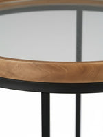 Table d'appoint ronde Nora de TOCO Meubles avec plateau en verre, bordure en bois naturel et pieds en métal noir
