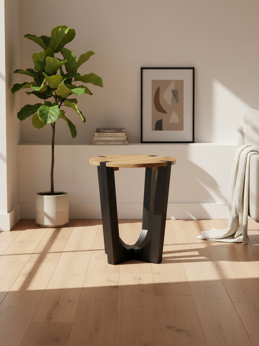 Table d'appoint Annie TOCO Meubles ronde avec plateau en bois naturel et base géométrique noire dans un salon moderne