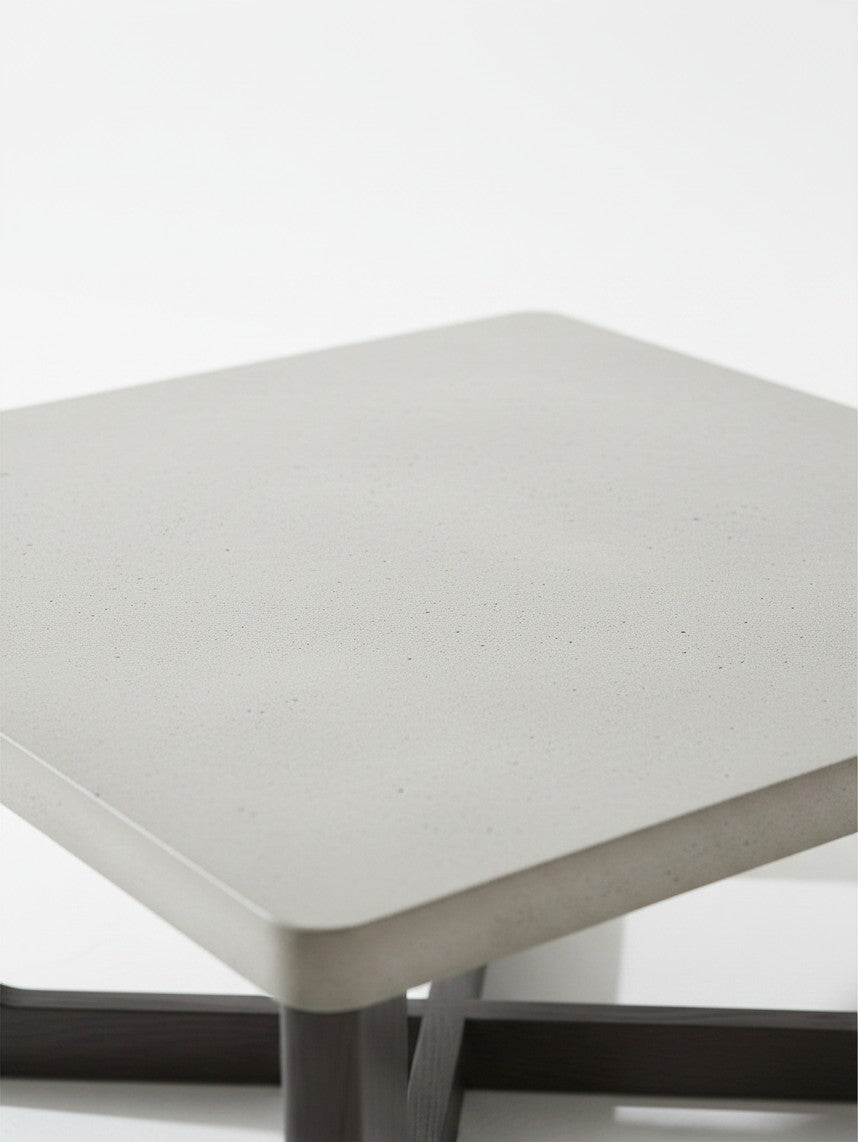Gros plan sur le plateau carré en béton gris de la table basse TOCO Meubles avec base en bois foncé
