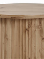 Gros plan sur le pied central cannelé en bois clair de la table basse ronde Montclair par TOCO Meubles