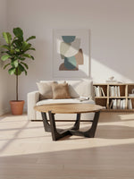 Table basse ronde TOCO Meubles avec plateau en bois naturel et base géométrique noire dans un salon lumineux