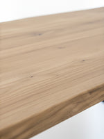 Gros plan sur le plateau en bois naturel de la table de salle à manger Nova par TOCO Meubles