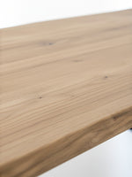 Gros plan sur le plateau en bois naturel de la table de salle à manger Nova par TOCO Meubles