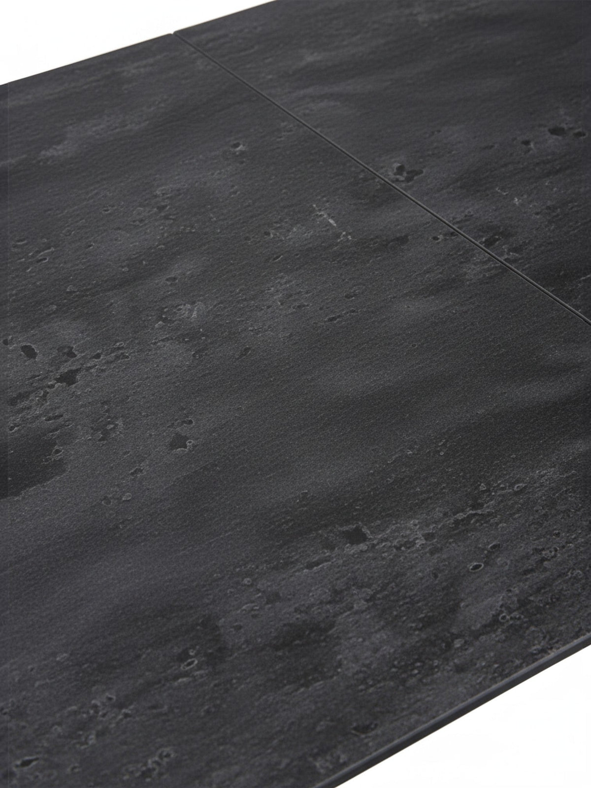 Gros plan sur le plateau en céramique noire texturée de la table de salle à manger Liora par TOCO Meubles