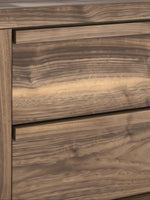 Gros plan sur les tiroirs de la table de chevet Alma de TOCO Meubles avec un fini effet bois au veinage prononcé.