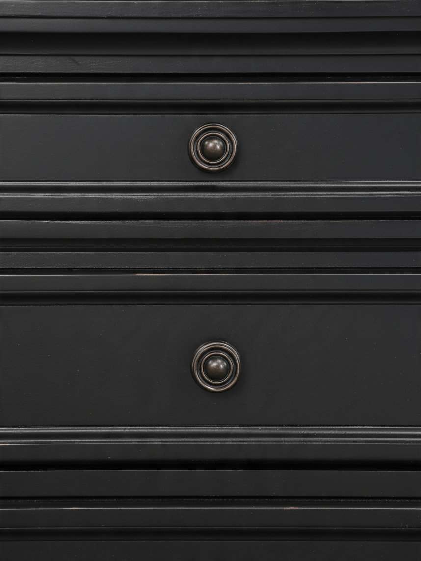 Gros plan sur les tiroirs de la table de chevet TOCO Meubles Margaux en bois noir effet usé avec boutons bronze